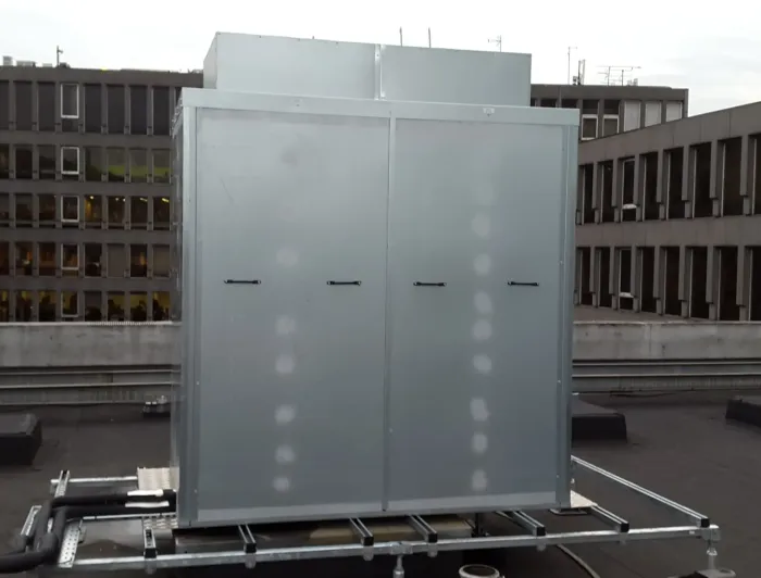 Row of galvanised steel acoustic enclosures on site